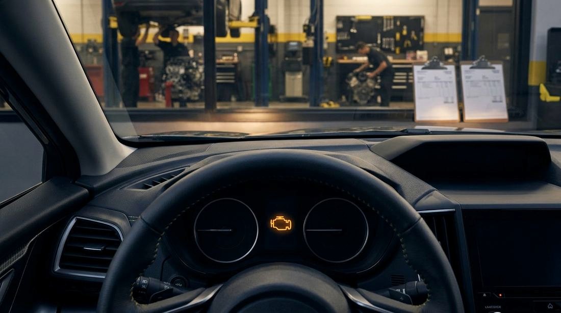 A dashboard with an amber engine warning light glowing